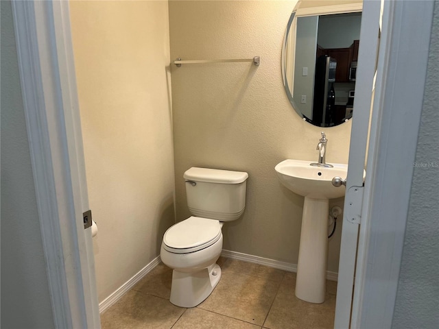 bathroom with tile patterned flooring, sink, and toilet