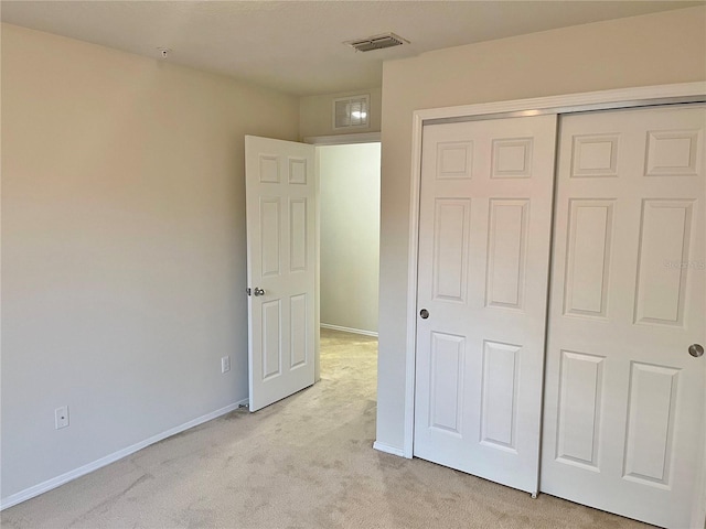 unfurnished bedroom with light carpet and a closet