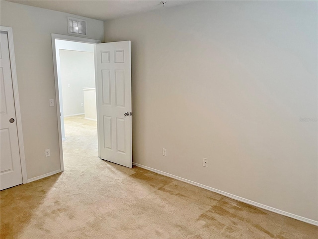 unfurnished room featuring light carpet