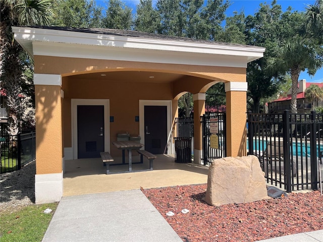 view of exterior entry featuring a fenced in pool and a patio