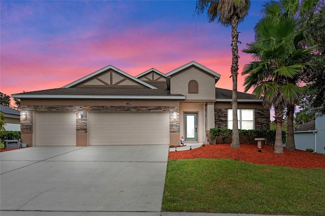 view of front of home with a garage and a yard