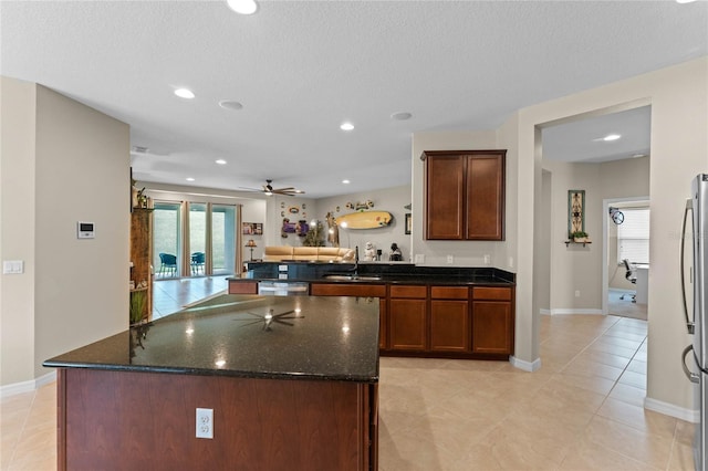 kitchen featuring sink, stainless steel appliances, dark stone countertops, and a healthy amount of sunlight