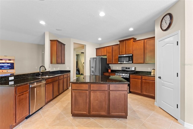 kitchen featuring stainless steel appliances, dark stone counters, light tile patterned floors, sink, and kitchen peninsula