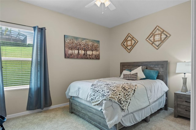 carpeted bedroom featuring multiple windows and ceiling fan