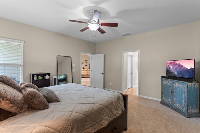 carpeted bedroom featuring ceiling fan and ensuite bath