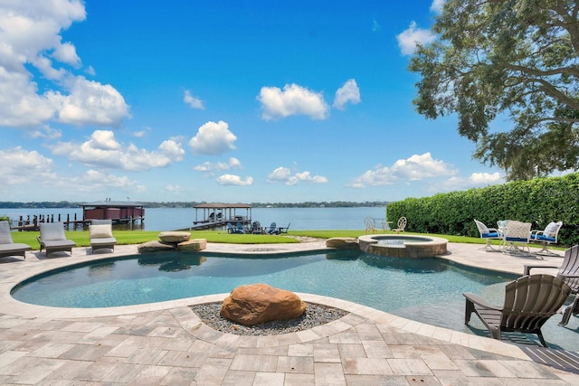 view of pool featuring a water view, a patio, and an in ground hot tub