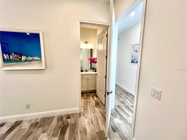 hallway with sink and light hardwood / wood-style floors