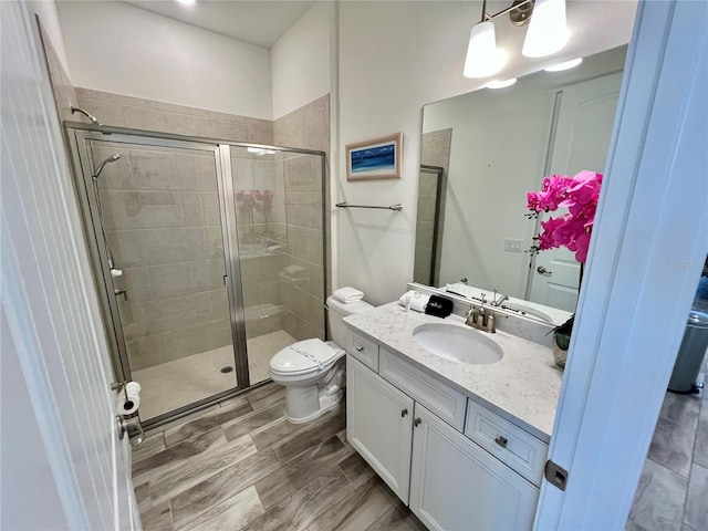 bathroom featuring hardwood / wood-style floors, an enclosed shower, vanity, and toilet