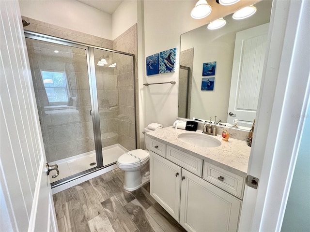 bathroom featuring vanity, a shower with shower door, toilet, and hardwood / wood-style flooring