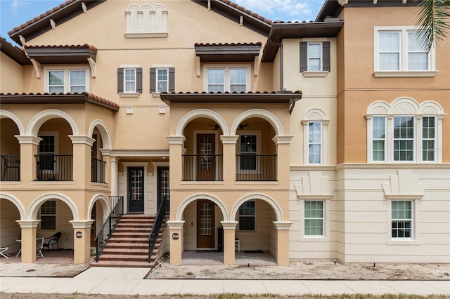 mediterranean / spanish-style home with a balcony and a patio area