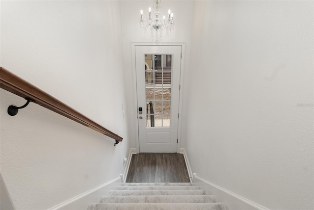 staircase with a notable chandelier and wood-type flooring