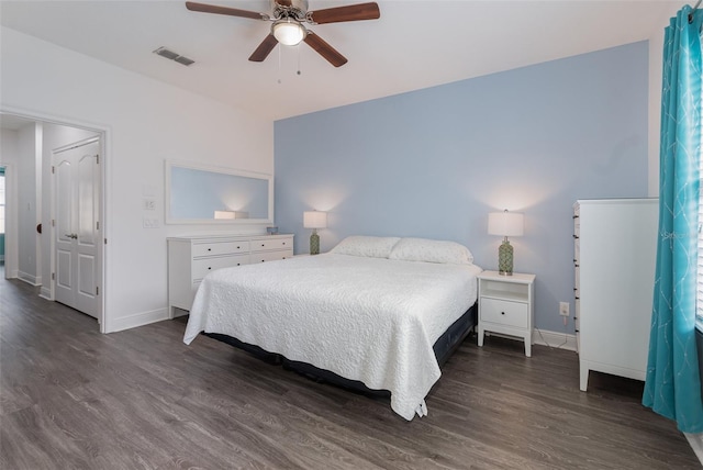 bedroom with baseboards, a ceiling fan, visible vents, and dark wood-type flooring