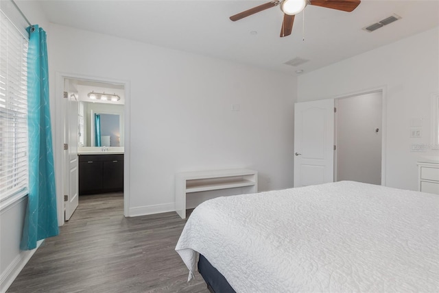 bedroom featuring visible vents, baseboards, dark wood-type flooring, a ceiling fan, and connected bathroom