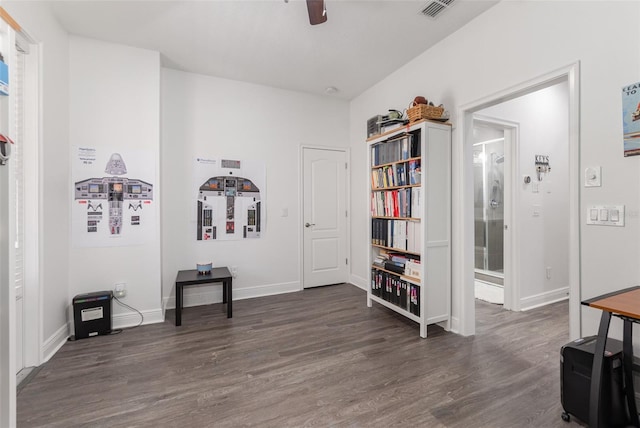 living area with baseboards, visible vents, a ceiling fan, and dark wood finished floors