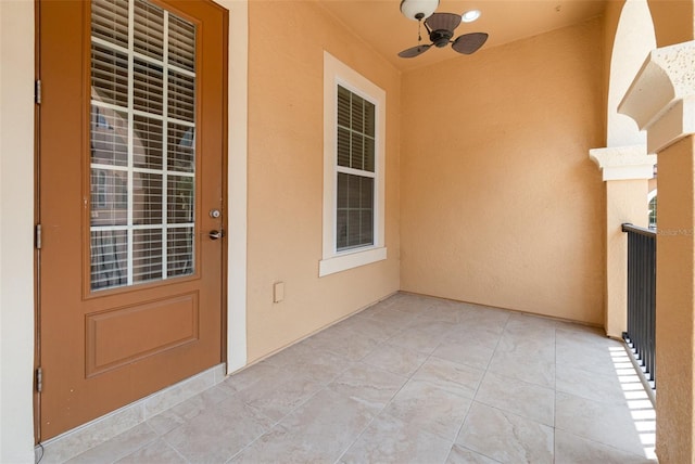 doorway to property featuring ceiling fan and stucco siding