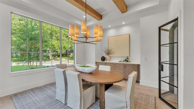 dining space with light wood-type flooring, beam ceiling, a chandelier, and a healthy amount of sunlight