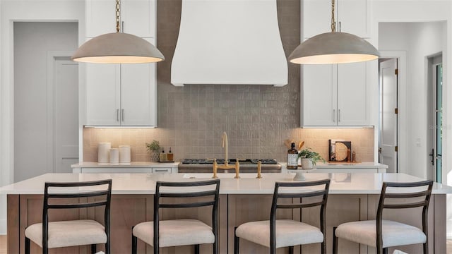 kitchen featuring wall chimney exhaust hood, light countertops, and decorative backsplash