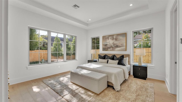 bedroom with visible vents, light wood-style floors, and multiple windows