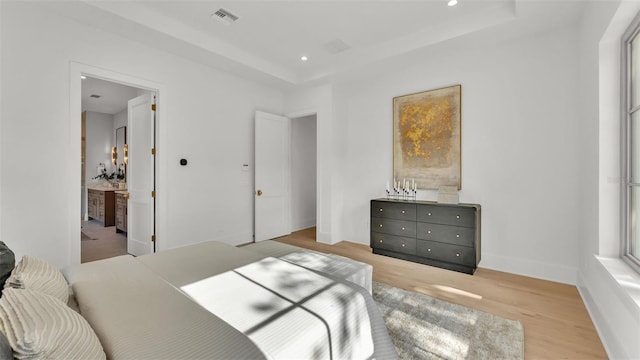 bedroom with recessed lighting, wood finished floors, baseboards, visible vents, and a raised ceiling