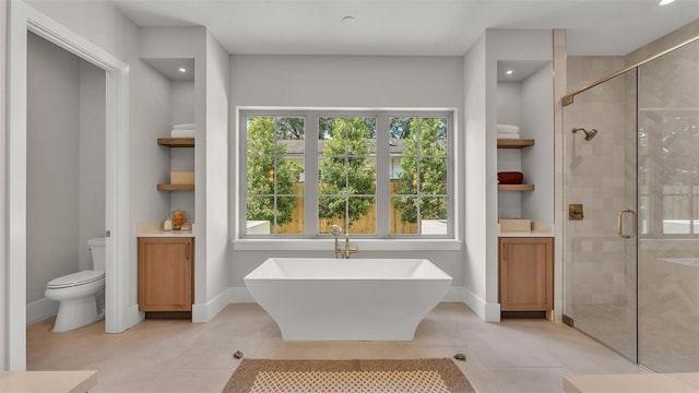 full bathroom featuring a freestanding tub, a stall shower, toilet, and tile patterned flooring