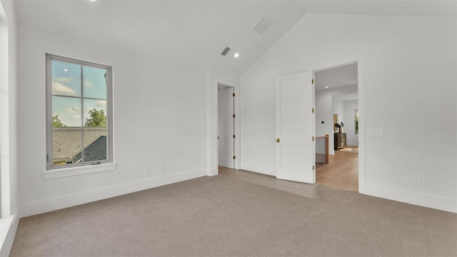 unfurnished room featuring lofted ceiling, visible vents, carpet floors, and baseboards