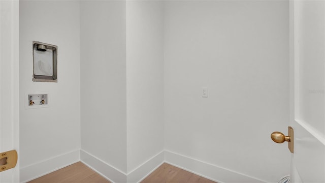 clothes washing area with baseboards, hookup for a washing machine, laundry area, and light wood-style flooring