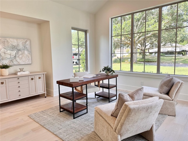 office space with baseboards, light wood-style flooring, and plenty of natural light