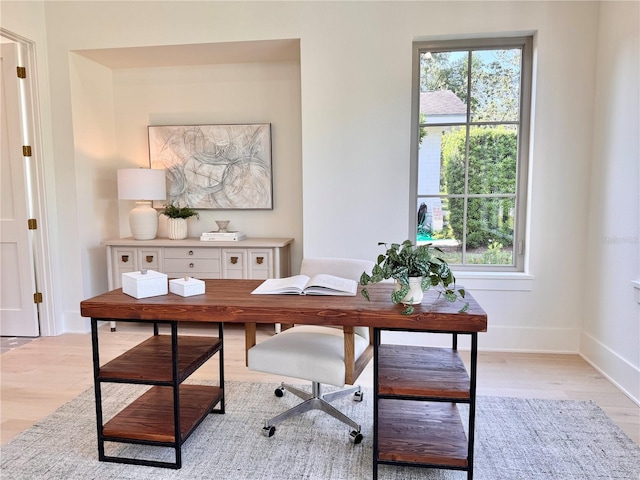 office area with baseboards, a healthy amount of sunlight, and light wood finished floors