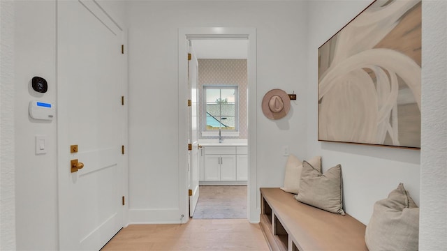 interior space featuring light wood-style floors, baseboards, and a sink