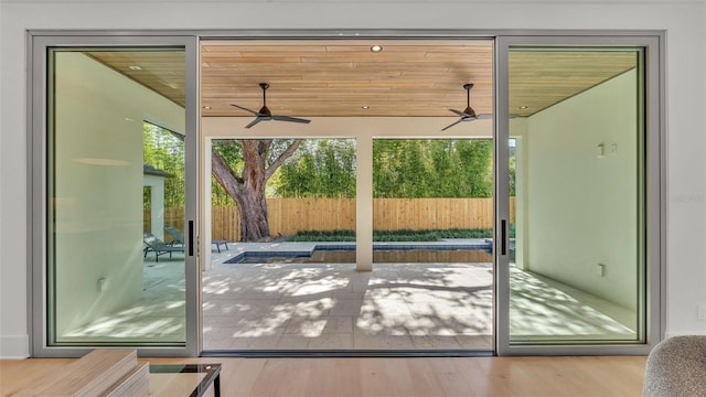 doorway to outside featuring wood finished floors and a ceiling fan