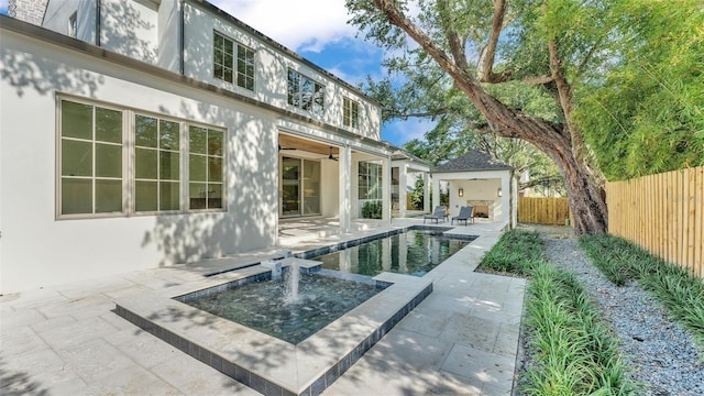 rear view of property with a patio area, a fenced in pool, a ceiling fan, stucco siding, and fence