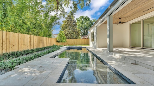 view of pool featuring ceiling fan, a fenced backyard, a pool with connected hot tub, and a patio area