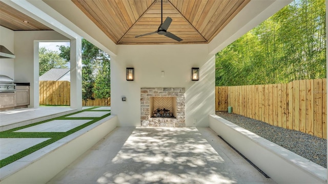 view of patio featuring an outdoor fireplace, fence private yard, and a ceiling fan