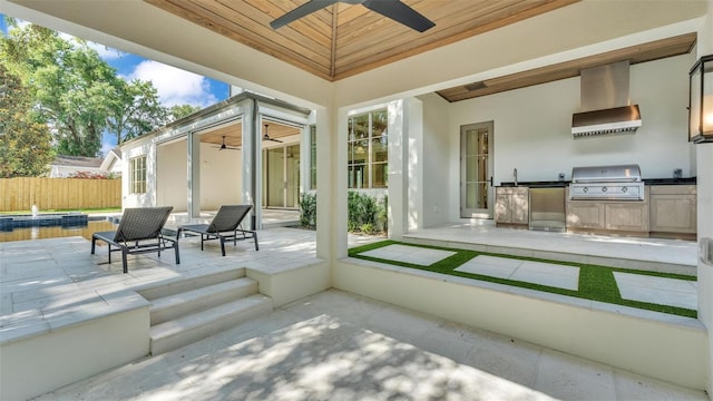 view of patio with area for grilling, ceiling fan, a grill, and fence