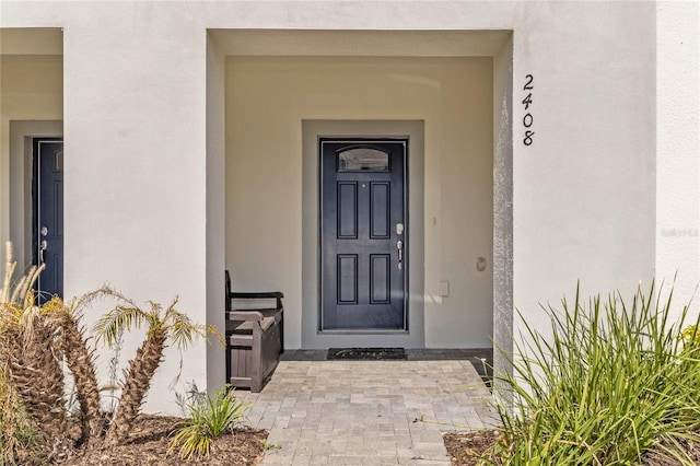 property entrance with stucco siding