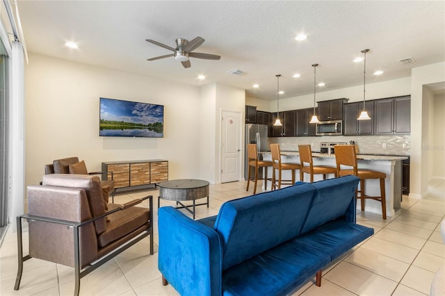 living room featuring a ceiling fan, recessed lighting, visible vents, and light tile patterned flooring