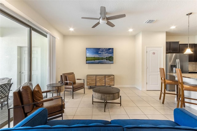 tiled living room with ceiling fan and a textured ceiling