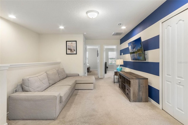 living area with recessed lighting, visible vents, a textured ceiling, and light colored carpet