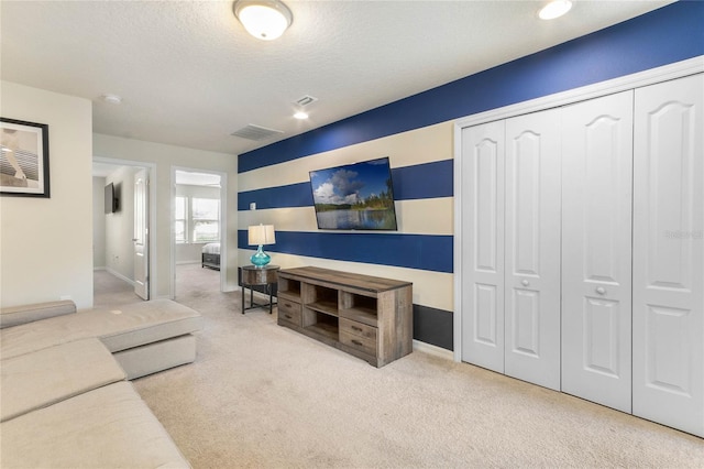 carpeted living room featuring a textured ceiling