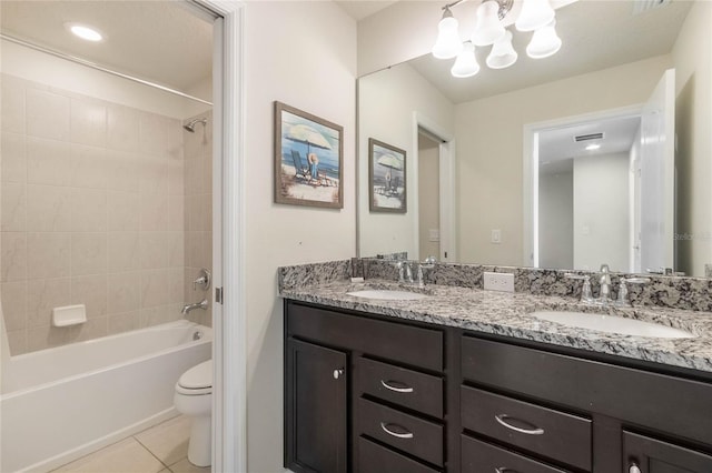 full bathroom with tile patterned flooring, tiled shower / bath, toilet, and vanity