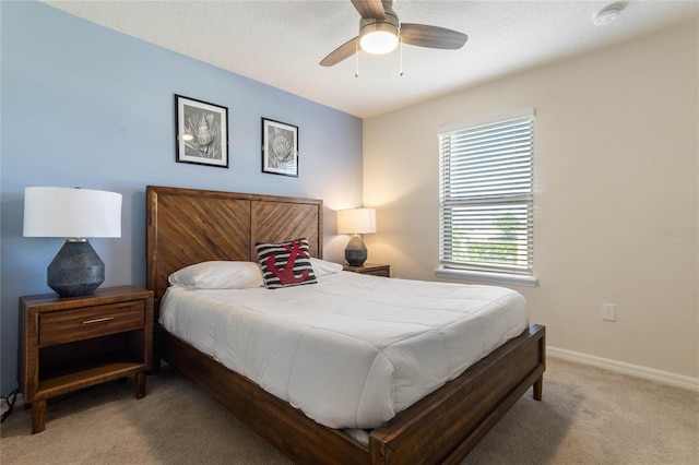 bedroom featuring ceiling fan, baseboards, and light colored carpet