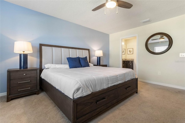 bedroom with ceiling fan, light carpet, and ensuite bathroom