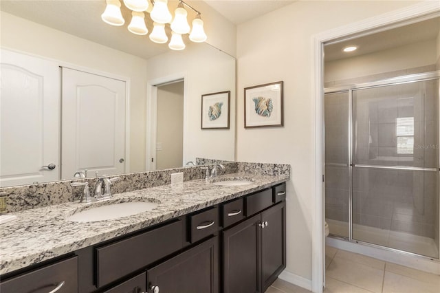 bathroom featuring tile patterned floors, a notable chandelier, walk in shower, and vanity