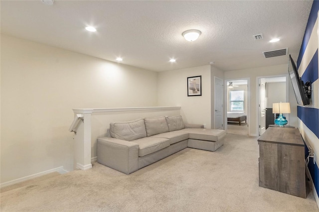 living room with a textured ceiling and light carpet