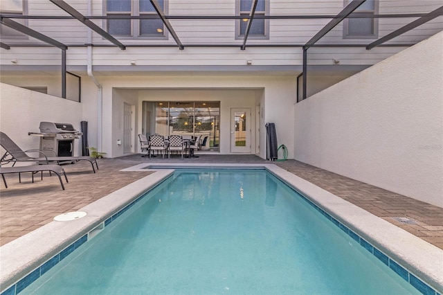 view of pool featuring outdoor dining space, a swimming pool, a patio area, and a lanai