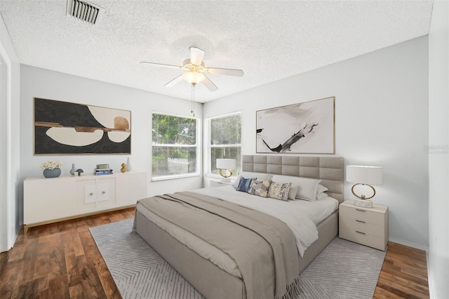 bedroom with a textured ceiling, ceiling fan, and hardwood / wood-style flooring