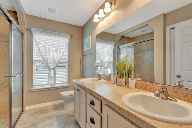 bathroom featuring vanity, toilet, a shower with shower door, and tile patterned floors