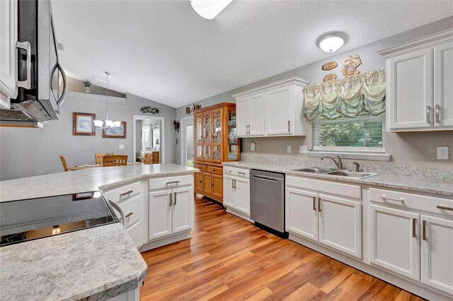 kitchen with decorative light fixtures, light hardwood / wood-style floors, stainless steel appliances, sink, and lofted ceiling