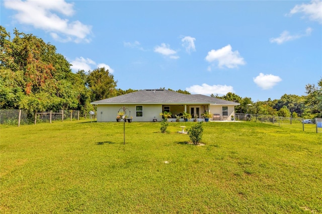 10604 SE 146th Ln, Summerfield, FL 34491 - back of property featuring a patio area, a yard, a fenced backyard, and stucco siding