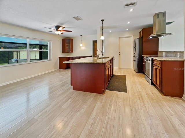 kitchen featuring visible vents, appliances with stainless steel finishes, decorative light fixtures, light stone countertops, and island exhaust hood